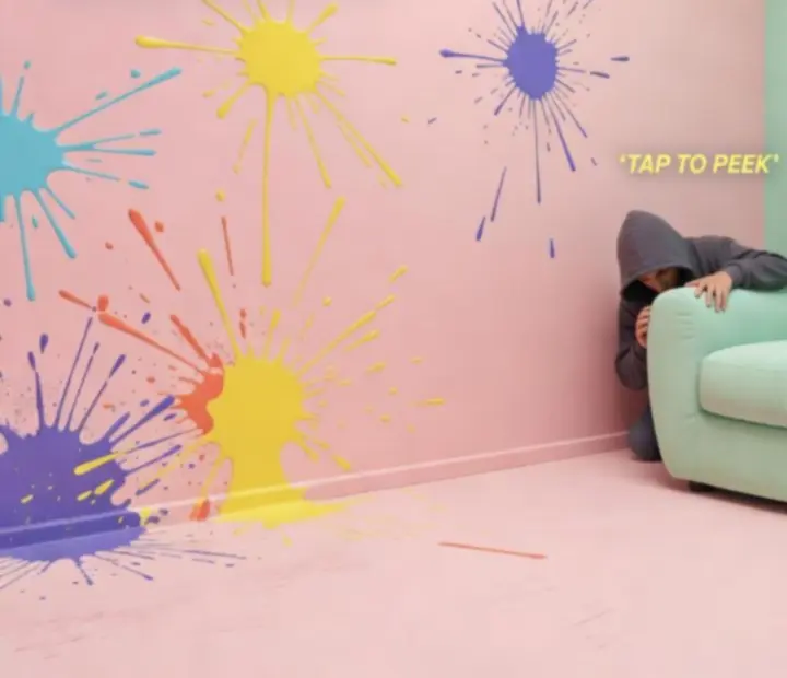 Gameplay screenshot showing a painted character hiding in a bright level